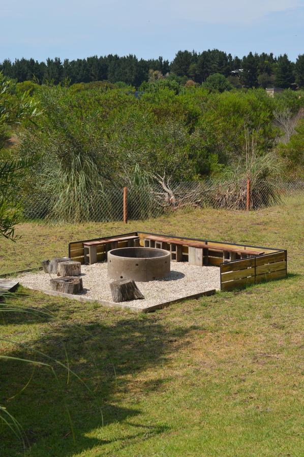 Fogón con bancos y troncos en el parque de la casa