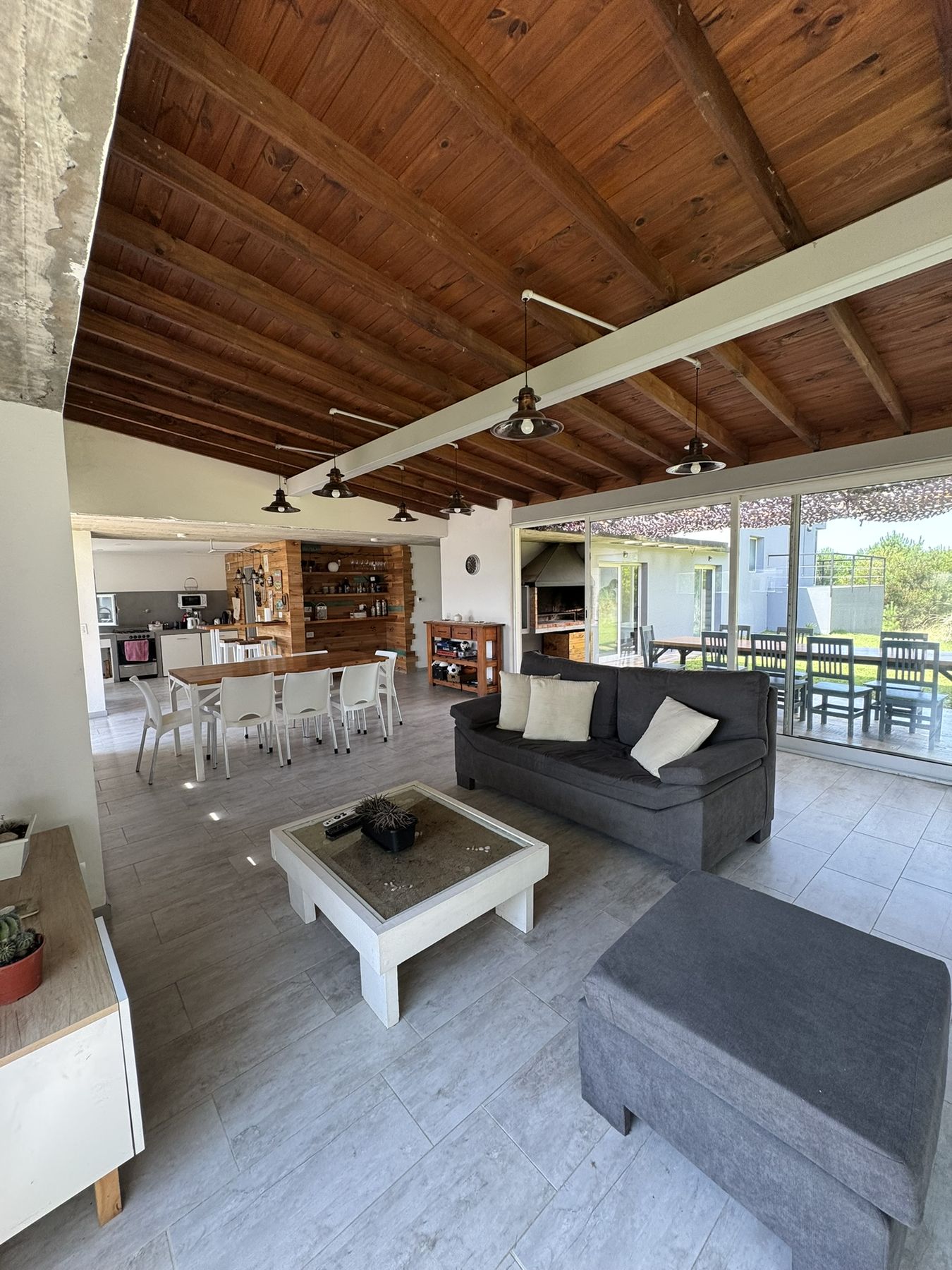 Living y comedor de la casa, con ventanales hacia la galería
