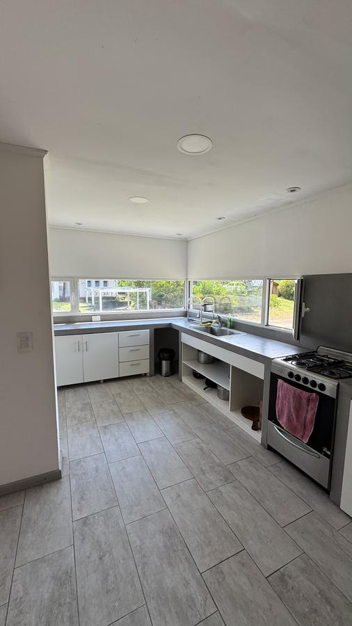 Cocina completa con mesada y ventanas corridas